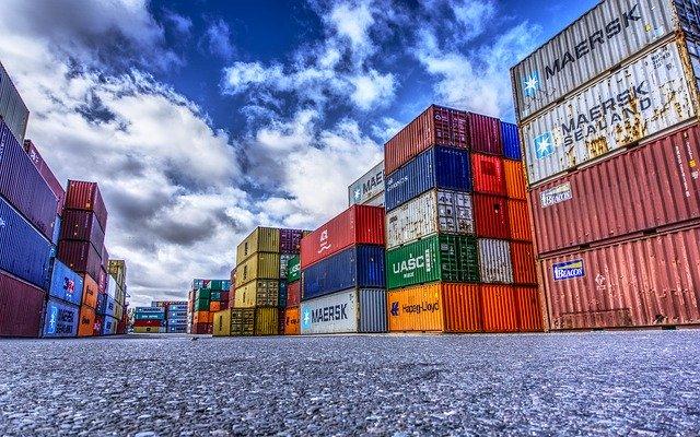 Gestapelte Container im Hafen vor blauem Himmel
